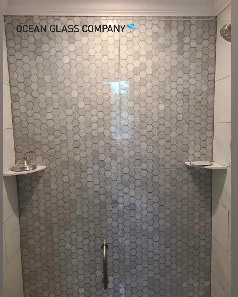 Shower glass beside a patterned tile wall
