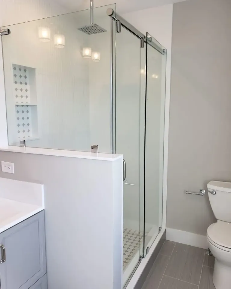 Sliding shower enclosure beside a half wall