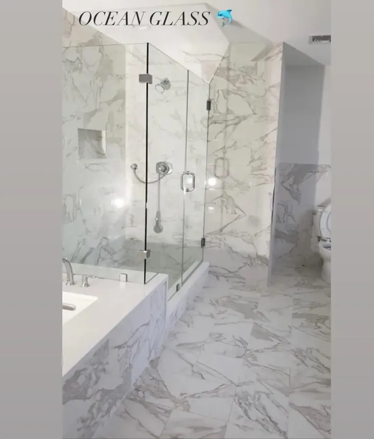 Custom glass beside a marble-patterned bathtub