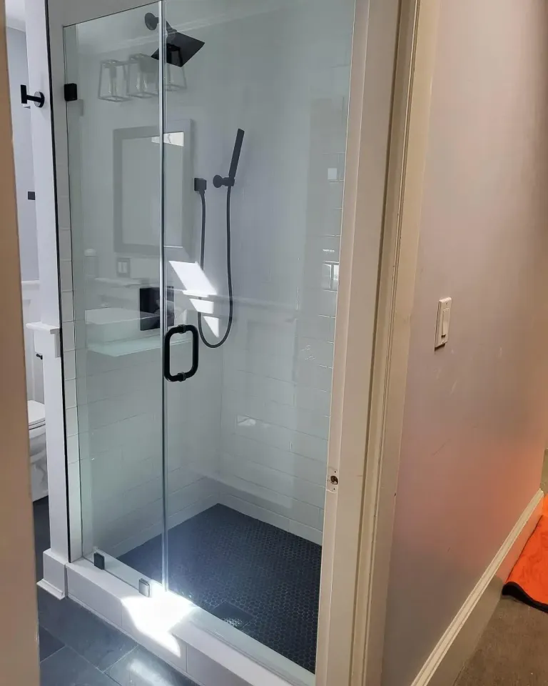 Frameless glass door fitted to a narrow shower opening