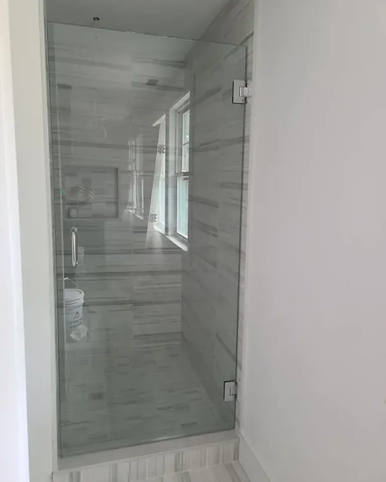 Glass shower door beside a window