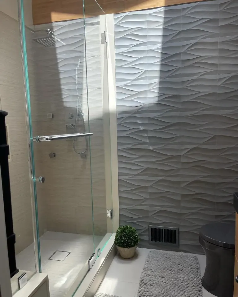Shower glass beside a textured tile wall