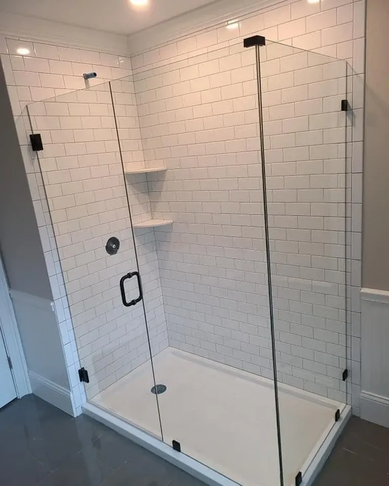 Hinged shower glass with dark hardware