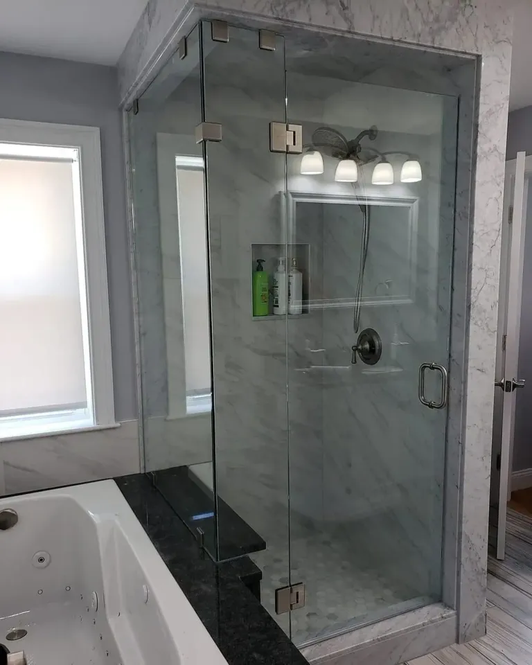 Hinged shower glass beside a bathtub