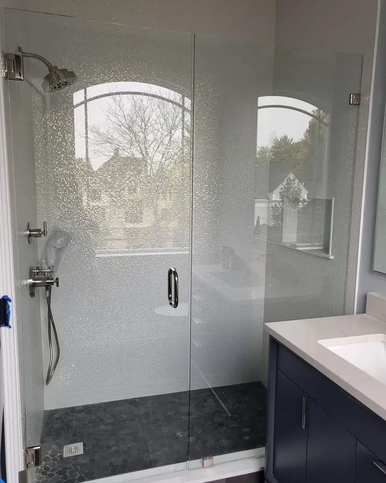 Glass shower door beside a bathroom vanity