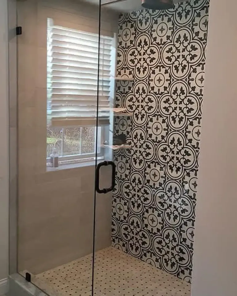 Glass door beside patterned shower tile